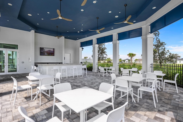 view of patio / terrace featuring ceiling fan, french doors, and a bar