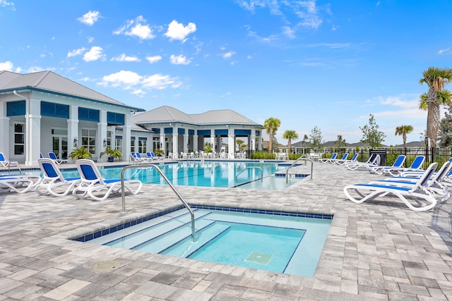 view of swimming pool featuring a hot tub and a patio area