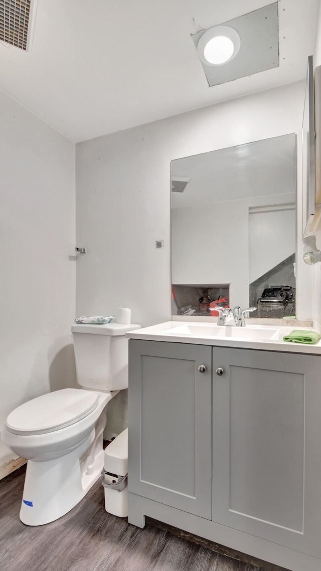 bathroom with hardwood / wood-style flooring, vanity, and toilet