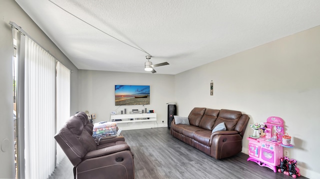 living room with a textured ceiling, hardwood / wood-style flooring, and ceiling fan