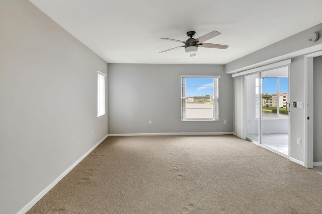 carpeted spare room with ceiling fan