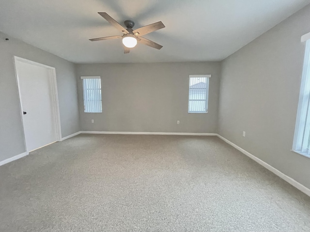 spare room with ceiling fan and carpet