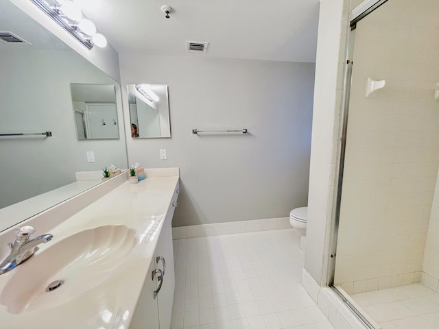 bathroom featuring tile patterned floors, a shower with door, vanity, and toilet