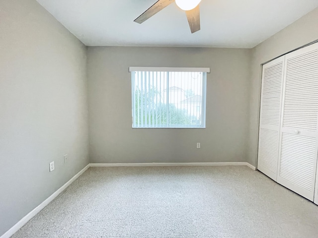 unfurnished bedroom with carpet floors, a closet, and ceiling fan