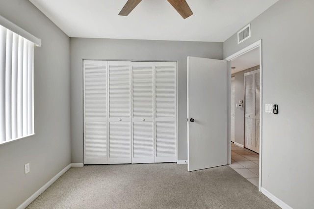 unfurnished bedroom with a closet, ceiling fan, and light colored carpet