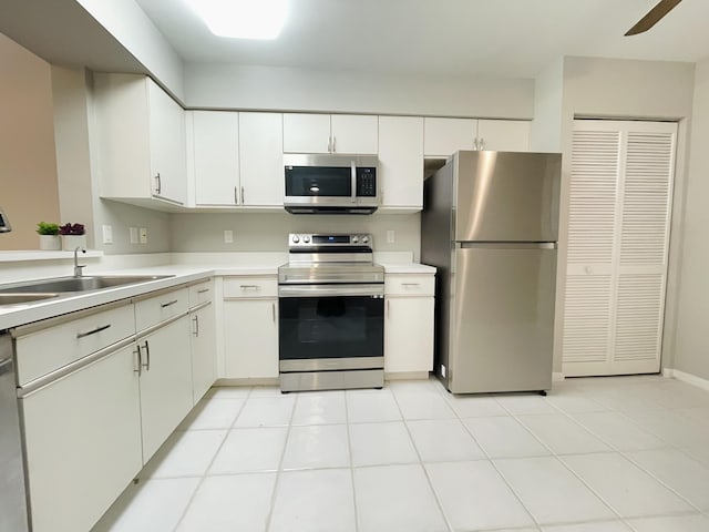 kitchen featuring white cabinets, ceiling fan, light tile patterned flooring, and stainless steel appliances