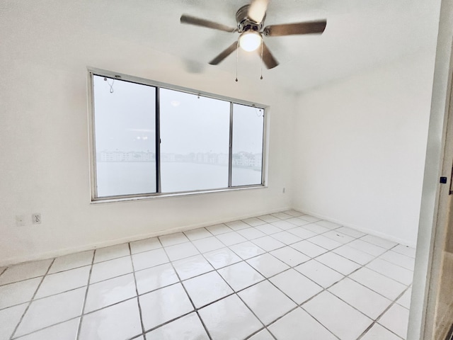 tiled spare room with ceiling fan