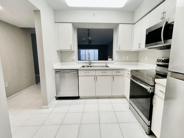 kitchen with sink, hanging light fixtures, stainless steel appliances, light tile patterned floors, and white cabinets