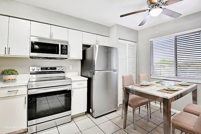 kitchen featuring white cabinets, light tile patterned floors, and stainless steel appliances