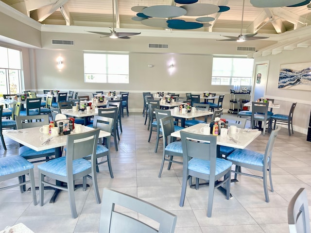 dining area with beamed ceiling, ceiling fan, light tile patterned flooring, and wooden ceiling