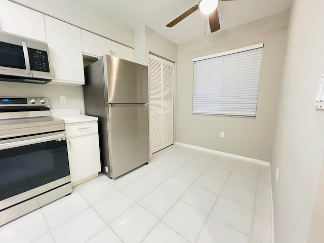 kitchen with white cabinets, appliances with stainless steel finishes, ceiling fan, and light tile patterned flooring