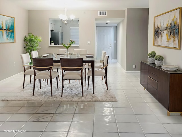 dining area with light tile patterned flooring and a notable chandelier