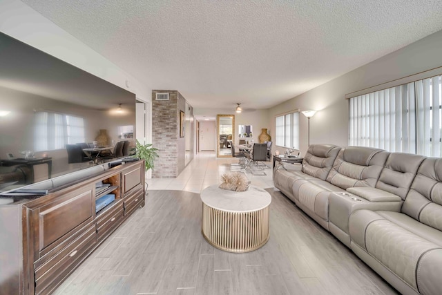 living room with brick wall and a textured ceiling