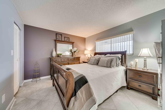 bedroom with a textured ceiling and light tile floors