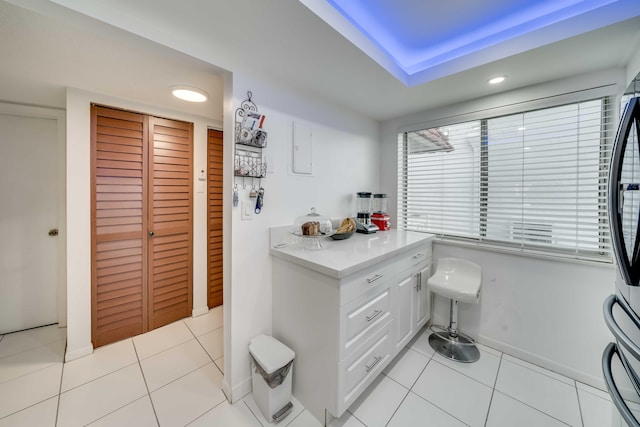 kitchen with white cabinetry and light tile floors