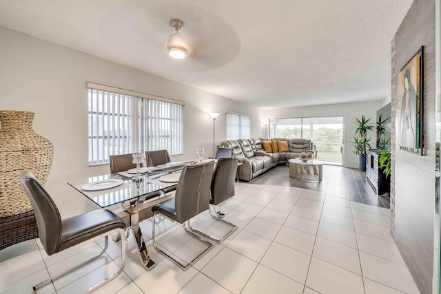 tiled dining area featuring plenty of natural light, ceiling fan, and a textured ceiling