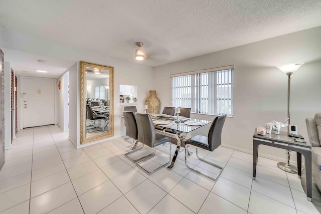 dining area featuring a textured ceiling and light tile floors