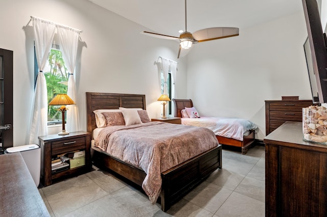 bedroom with ceiling fan, light tile patterned floors, and lofted ceiling