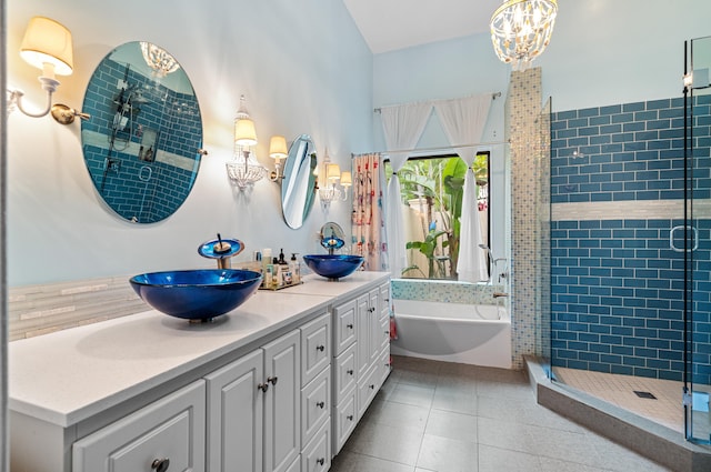 bathroom with plus walk in shower, tile patterned flooring, vanity, and a notable chandelier