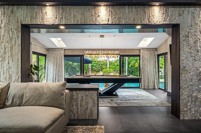 recreation room featuring a skylight, billiards, and an inviting chandelier