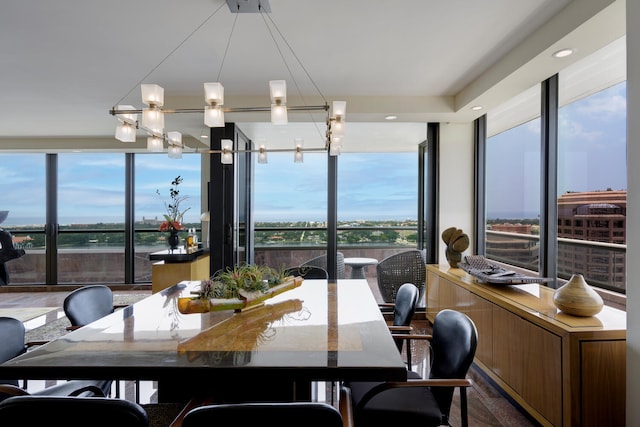 dining space with a notable chandelier, a healthy amount of sunlight, and a wall of windows