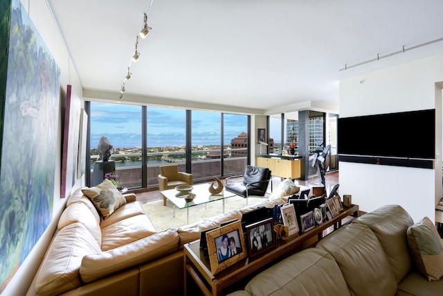 living room featuring a wall of windows, a water view, and rail lighting