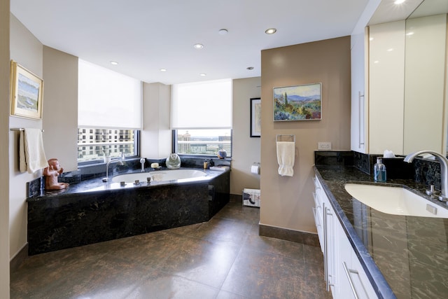 bathroom with tile floors, vanity, and a tub