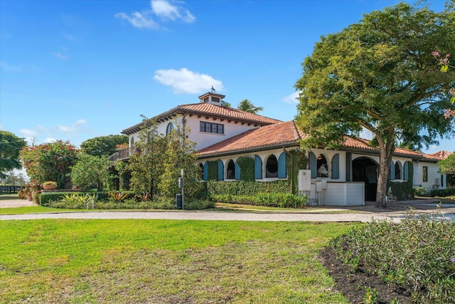 mediterranean / spanish home with a garage and a front yard