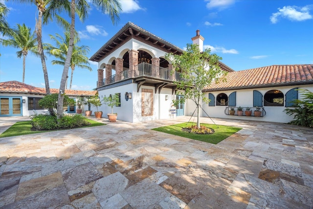 mediterranean / spanish-style house featuring a balcony and a patio area