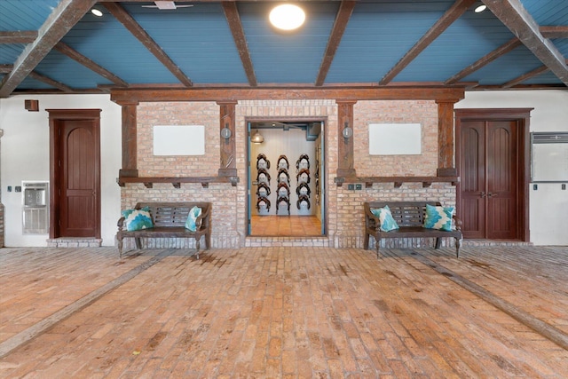 unfurnished living room featuring hardwood / wood-style floors and lofted ceiling with beams