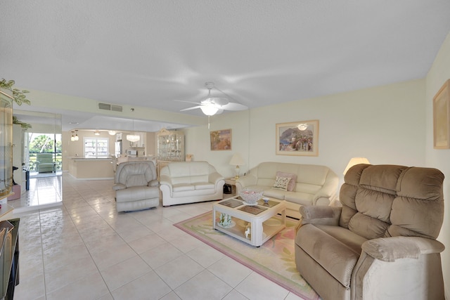 tiled dining space with a textured ceiling and ceiling fan