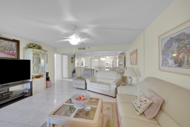 tiled living room featuring ceiling fan and a textured ceiling