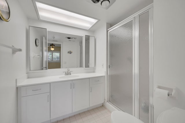 bathroom with tile patterned flooring, vanity, and a shower with door