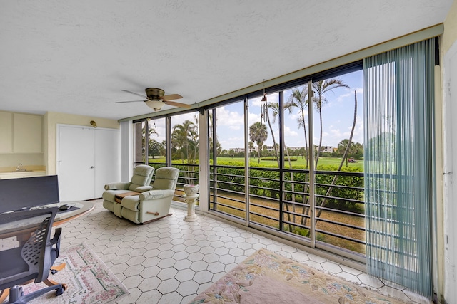 living area with ceiling fan, light tile patterned floors, and a textured ceiling