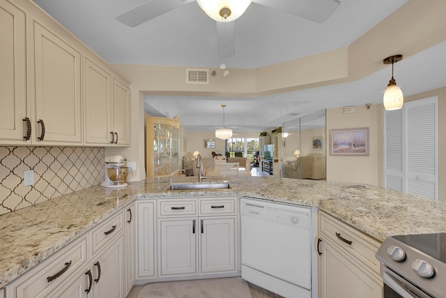 kitchen featuring stainless steel refrigerator, light stone countertops, sink, kitchen peninsula, and decorative light fixtures