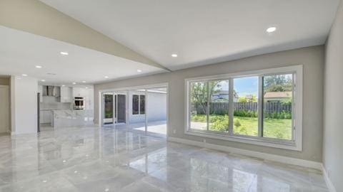 unfurnished room with lofted ceiling and light tile floors