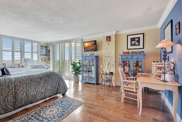 bedroom featuring ornamental molding, a textured ceiling, and hardwood / wood-style flooring