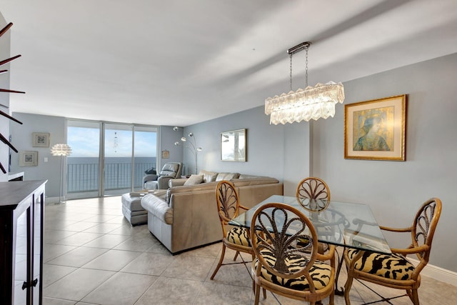 dining room with a wall of windows, light tile floors, and an inviting chandelier