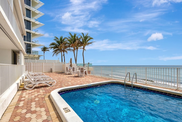 view of swimming pool with a water view