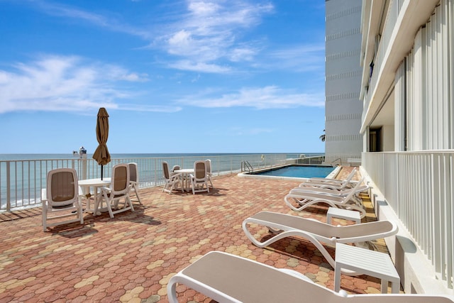 view of patio featuring a community pool and a water view