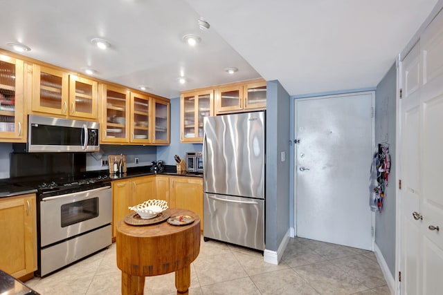 kitchen featuring light brown cabinets, light tile floors, and appliances with stainless steel finishes