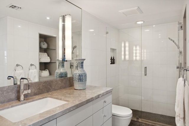 bathroom with vanity, toilet, and a shower with shower door