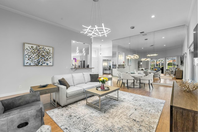 living room featuring crown molding, light wood-type flooring, and an inviting chandelier