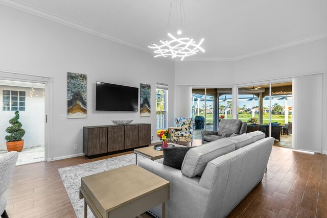 living room with ornamental molding, hardwood / wood-style floors, and a chandelier