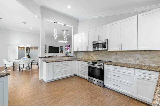 kitchen featuring stainless steel appliances, crown molding, white cabinets, and kitchen peninsula