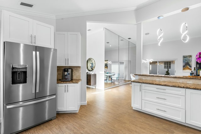 kitchen with stone countertops, ornamental molding, white cabinets, and stainless steel refrigerator with ice dispenser