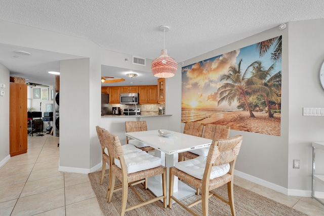 dining room with light tile patterned floors and a textured ceiling