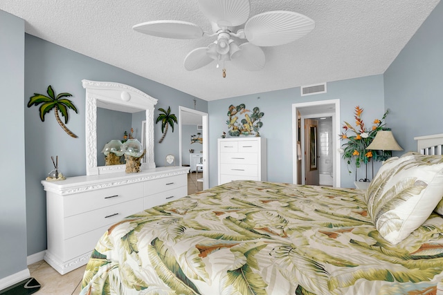 tiled bedroom with a textured ceiling and ceiling fan