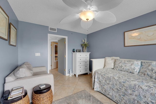 living room featuring a textured ceiling, ceiling fan, and light tile patterned floors