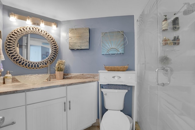 bathroom featuring vanity, an enclosed shower, and toilet